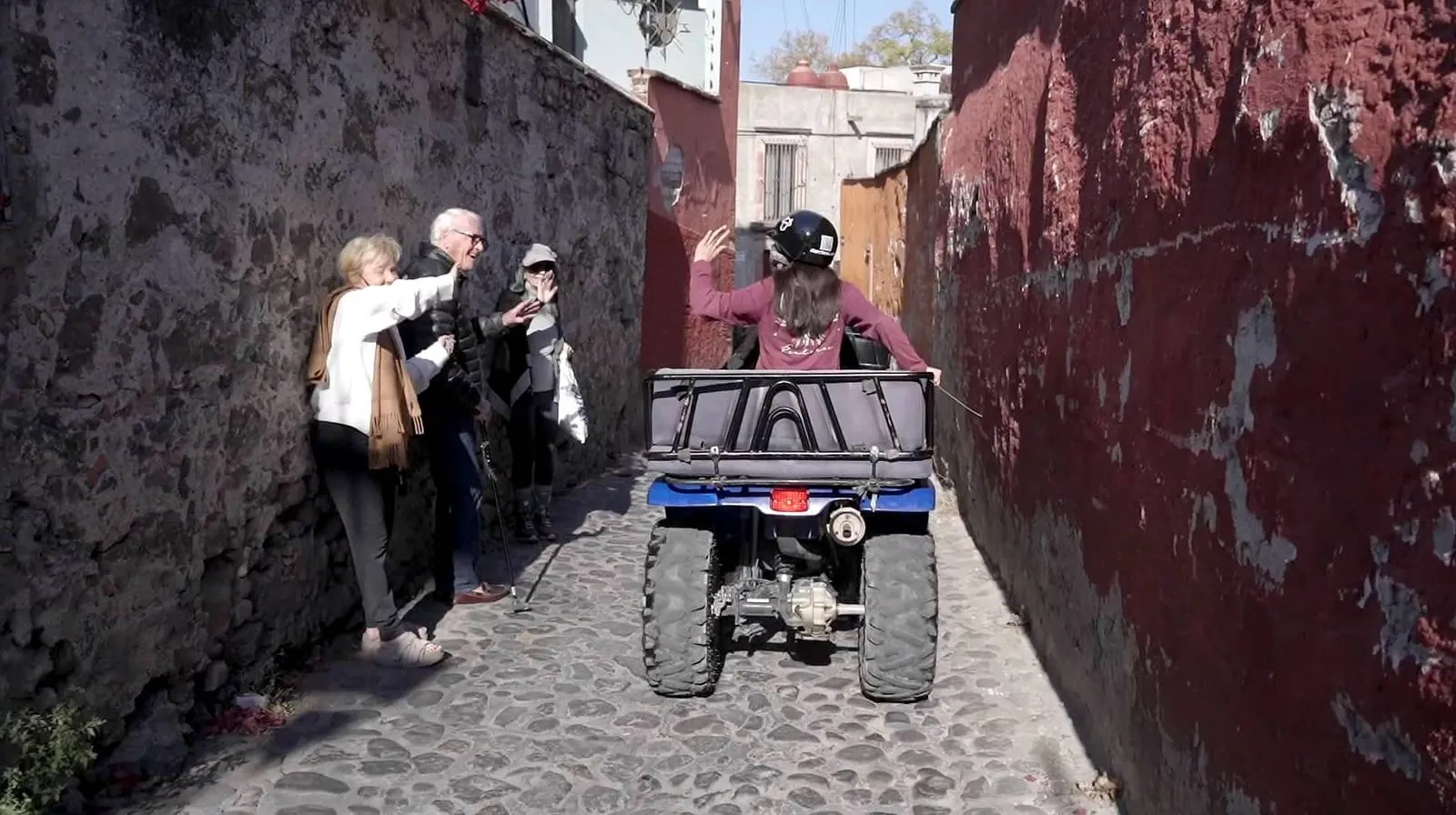 ATV adventure and historic alleys with CONTACT GUEY TOURS Tourists waving to a guide on an ATV during a cultural cobblestone alley ride with CONTACT GUEY TOURS